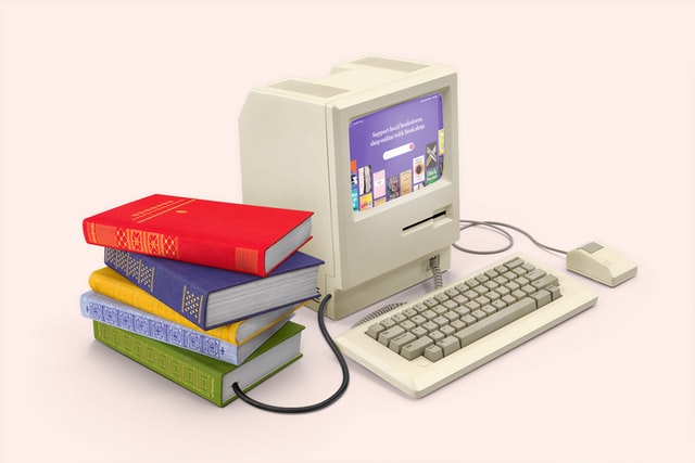 computador branco com fios ligados a livros